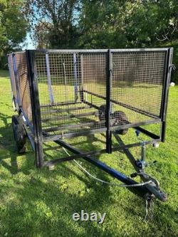 Remorque à double essieu 10 pieds x 5,5 pieds sans freins, côtés en treillis et rampe. Nécessite une planche de sol.